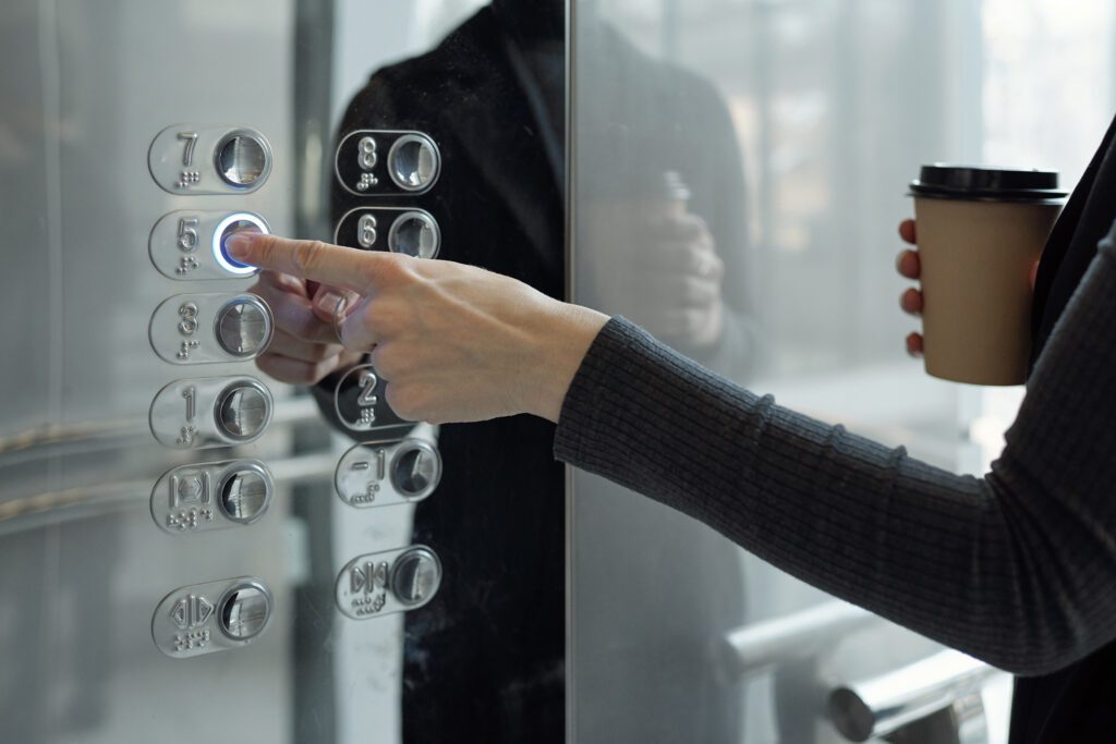 Hand pressing elevator button