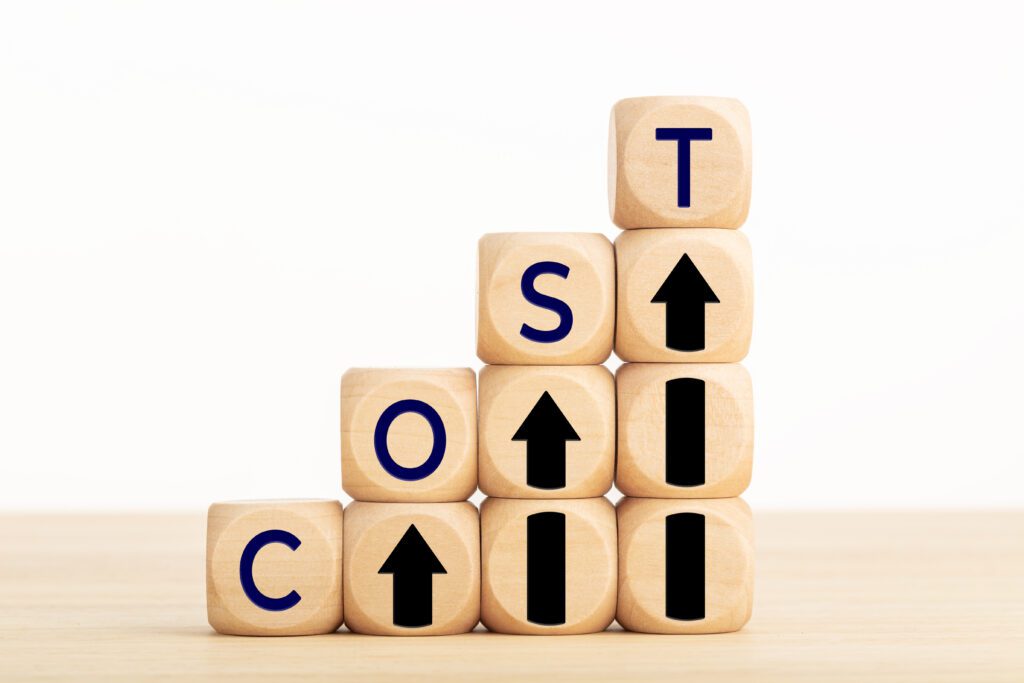 Cost growth concept. Text and arrow icon on wooden blocks.